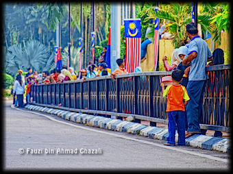 Sebahagian para penonton bersiap sedia di sepanjang laluan perbarisan