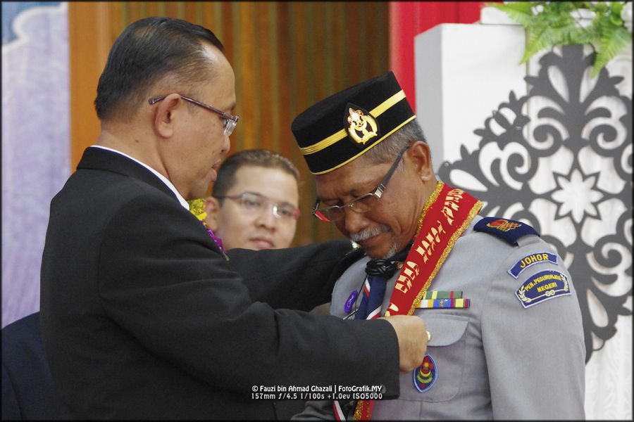 Tokoh Guru dikalungkan selempang anugerah.